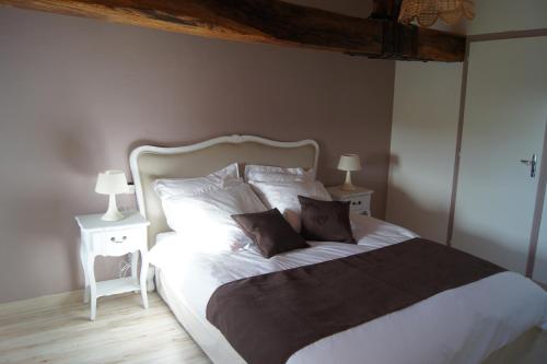 una camera da letto con un letto grande con due comodini di Corps de ferme spacieux avec grand jardin, 10 personnes a LʼAiguillon-sur-Vie