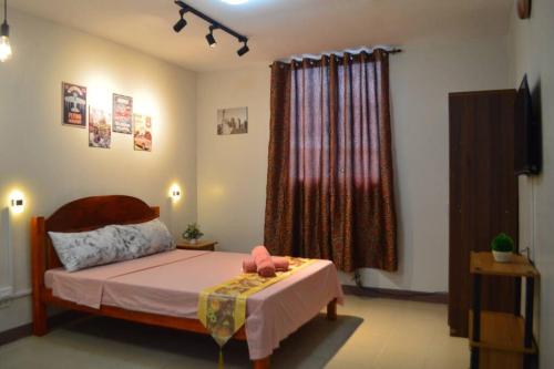 a bedroom with a bed with a pink stuffed animal on it at Dencio's Crib in Mactan