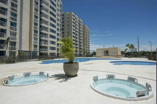 two pools in a patio with a plant in a pot at Confortable apartamento en conjunto Puerto Azul Club House in Ricaurte
