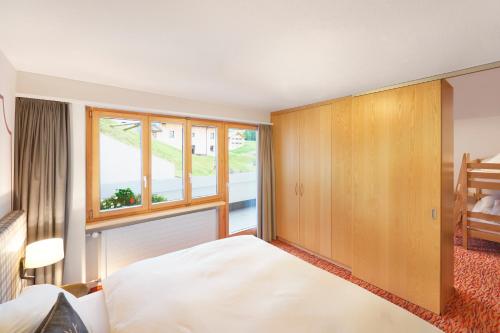 a bedroom with a large bed and a window at Hotel TURNA Malbun in Malbun