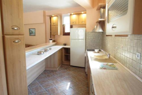 a large kitchen with a white refrigerator in it at Christie's ground floor apartment by the sea in Kato Gatzea