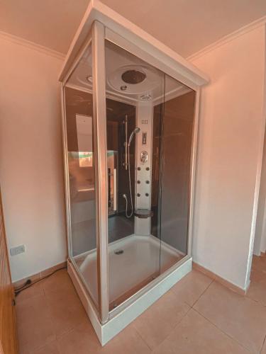 a glass shower in a corner of a room at Buenos Vientos Complejo - Termas Chajarí in Chajarí