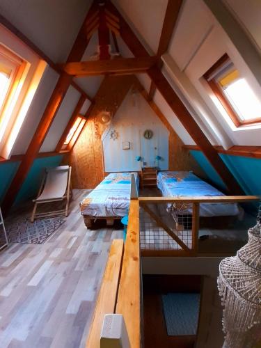 a attic room with two beds and a table at WadLeuk! in Den Helder