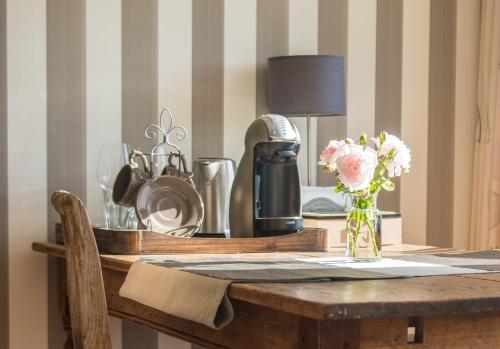 een houten tafel met een vaas met bloemen erop bij Broeks' Bed En Brood in Meerkerk