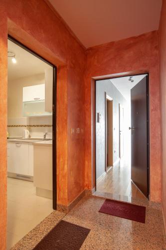 an orange hallway with a door and a kitchen at Apartment City Strand in Makarska