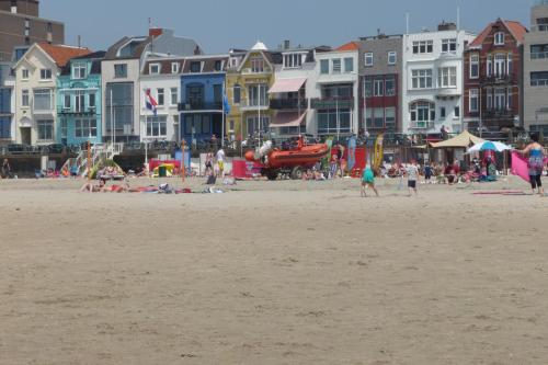 a group of people on a beach with buildings at Rijksmonument Havenzicht, met zeezicht, ligging direct aan zee en centrum in Vlissingen