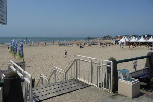 a beach with a crowd of people and umbrellas at Rijksmonument Havenzicht, met zeezicht, ligging direct aan zee en centrum in Vlissingen