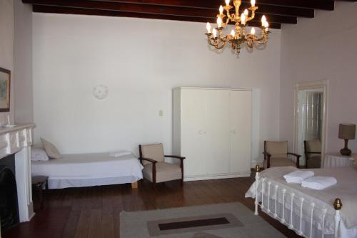 a bedroom with two beds and a chandelier at Karoopark Guest House in Graaff-Reinet