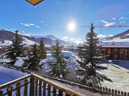 a view from a balcony with snow covered trees at La Stua Livigno in Livigno