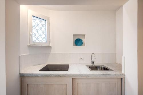 una cocina con fregadero y ventana en Suitebienvenido, en Massa Lubrense