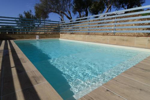 a swimming pool with blue water in front of bleachers at Villa Trappeto in Trappeto