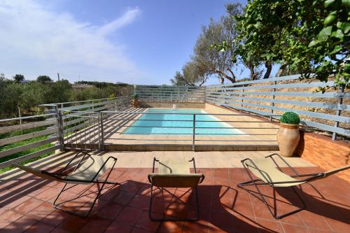 a swimming pool with two chairs and a table at Villa Trappeto in Trappeto
