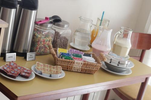 a table with plates of food and bottles of milk at Hotel Catedral in Luján
