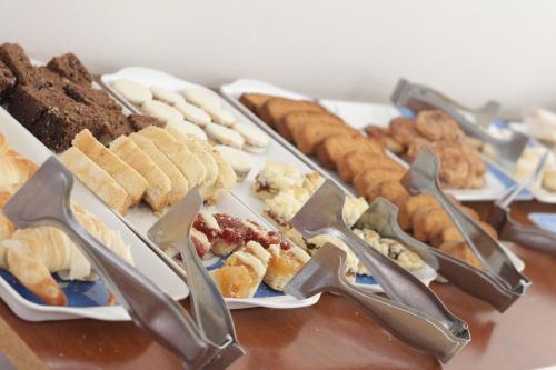 une table avec plusieurs types de pâtisseries différentes sur les assiettes dans l'établissement Hotel Catedral, à Luján