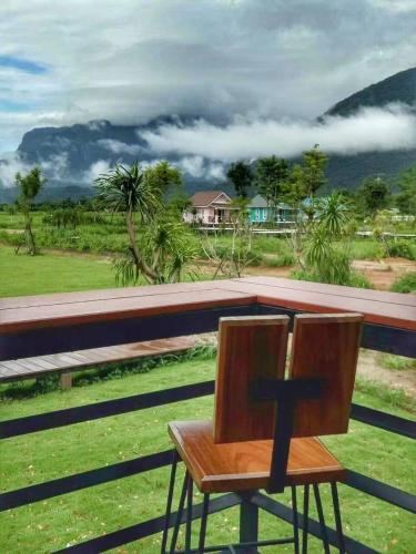 a wooden chair sitting on top of a porch at Ban Thung Talay Mok Chiangdao in Chiang Dao