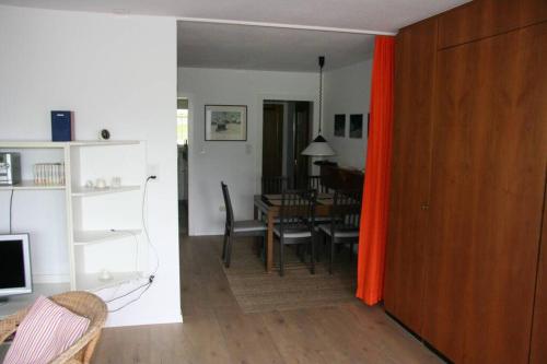 a living room and dining room with a table and a red curtain at Salve 8 in Leukerbad