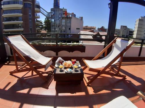 dos sillas y una mesa con comida en un balcón en la Hostería Santa Bárbara de Villa Gesell