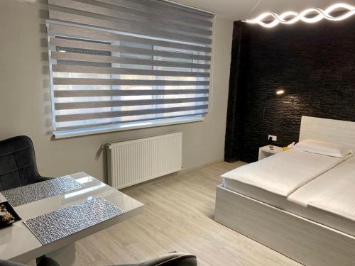 a bedroom with a bed and a desk and a window at Apartament Catalin 1 in Arad
