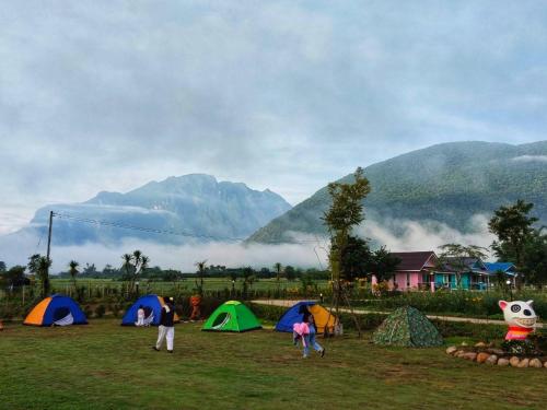 a group of people standing in a field with tents at Ban Thung Talay Mok Chiangdao in Chiang Dao