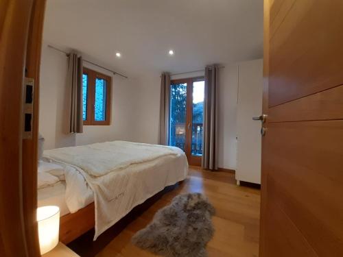 a bedroom with a bed and a window and a door at Chalet soFlo -5 FLOCONS OR - 3 Vallées - Saint-Martin-de-Belleville-9personnes-130m2 in Saint-Martin-de-Belleville