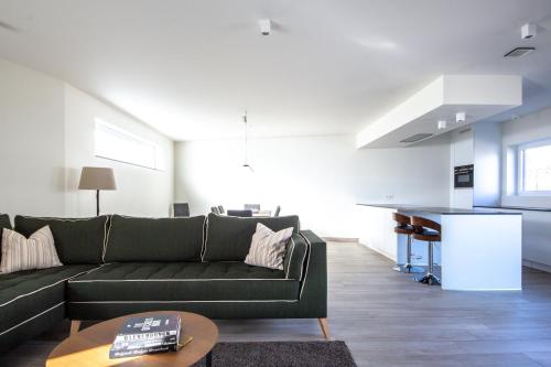 uma sala de estar com um sofá verde e uma mesa em Red Rabbit Tourist and Business Flats - I & II em Zele