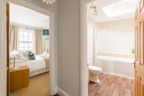 a bathroom with a bed and a toilet and a tub at Grundy's Lane Apartments in Malvern Wells