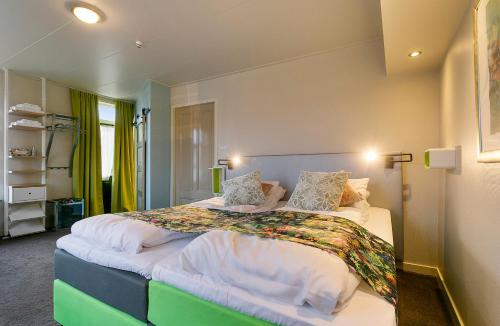 a bedroom with a large bed with white sheets and pillows at Bed & Breakfast Marrum in Marrum