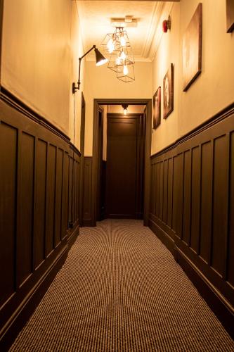 a hallway with a black door and a room with a hallwayngth at Abbey Court Guest House in Carlisle