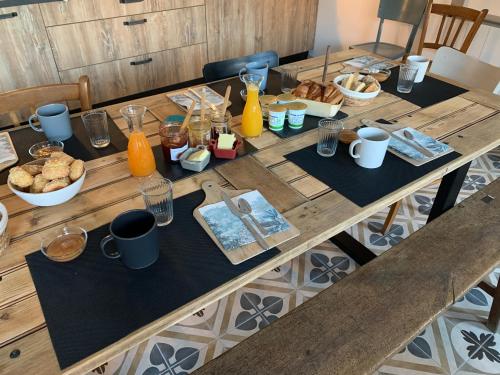 ein langer Holztisch mit Frühstückszutaten drauf in der Unterkunft L'Escale Bellifontaine in Ury