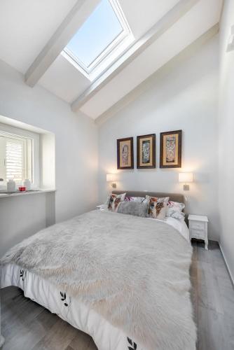 a bedroom with a large bed with a skylight at Jully apartment with swimming pool in Babino Polje
