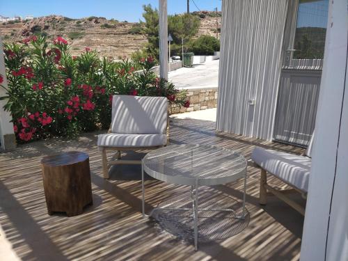 a patio with a table and two chairs and a table and a stump at Psathaki in Kimolos