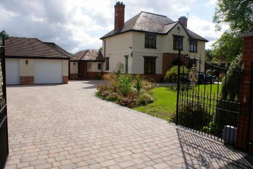 a brick driveway in front of a white house at Orchard Side Bed and Breakfast in Great Malvern