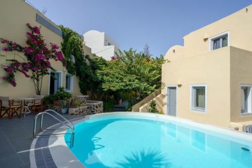 a swimming pool in front of a building at Ersi Villas in Firostefani