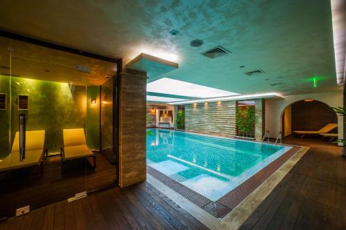 a large swimming pool in a building at Spa Hotel Ezeretz Blagoevgrad in Blagoevgrad