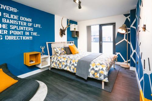 a bedroom with a bed and a blue wall at Funky City Apartment - Secure Parking - WiFi - Sleeps 6 - No Parties in Belfast