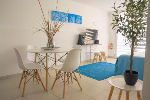 a dining room with a table and chairs and a potted tree at Vista Abanico in Maitencillo