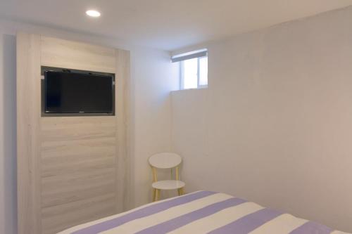 a bedroom with a bed and a flat screen tv at Vista Abanico in Maitencillo