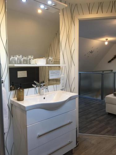 ein Badezimmer mit einem weißen Waschbecken und einem Spiegel in der Unterkunft Ferienwohnung Haagedoernchen in Nettetal