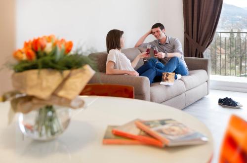 a man and woman sitting on a couch in a living room at Agrifoglio in Baveno