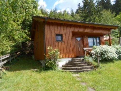 Cabaña de madera pequeña con escaleras que conducen a ella en Selbstversorger Hütte Rechberg, en Rechberg