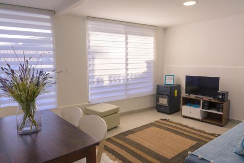a living room with a table and a television at Vista Abanico in Maitencillo