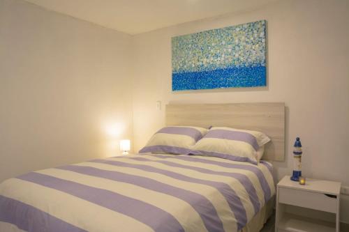 a bedroom with a bed with a painting on the wall at Vista Abanico in Maitencillo