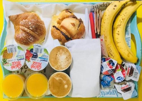 un cestino per il pranzo con muffin, pane, banane e succo d'arancia di B&B Colorful Suite Yard a Roma