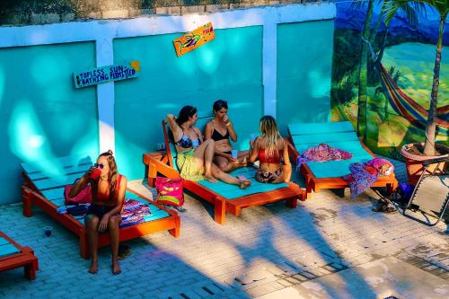 a group of women sitting on benches in front of a wall at Blue Iguana in Sámara