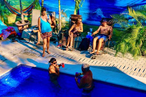 a group of people sitting around a swimming pool at Blue Iguana in Sámara