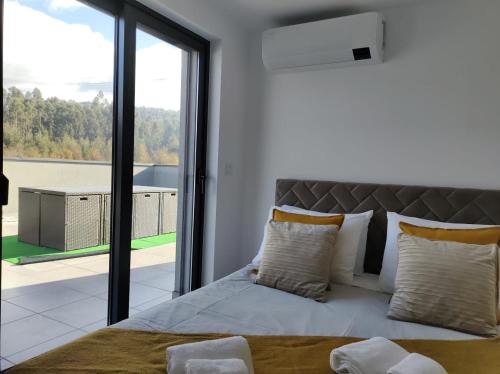 een slaapkamer met een bed en een groot raam bij Apartment - Vista Alegre in Ponte de Lima