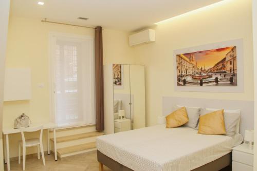 een witte slaapkamer met een bed en een tafel bij DOMUS DIVI - appartamento nel cuore di Roma in Rome