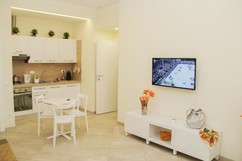 een keuken met witte kasten en een witte tafel en stoelen bij DOMUS DIVI - appartamento nel cuore di Roma in Rome