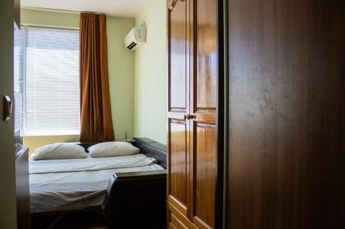 Central Couch Studio في بوموري: غرفة نوم صغيرة بها سرير ونافذة
