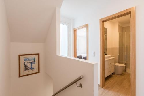 a staircase leading to a bathroom with a toilet and a mirror at Prainha Luxury Apartment in Alvor